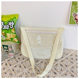 Close-up of cream canvas ita bag featuring white lace trim and gold Getlucky print