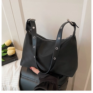 Détail du sac sous le bras en nylon noir avec œillets argentés et boucles en métal