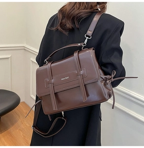 Detail of vintage dark brown soft leather crossbody bag with buckle straps and top handle