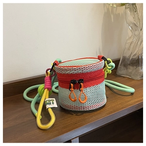 Detail of multi-color mesh cylinder mini bag with woven rope strap and brand tag