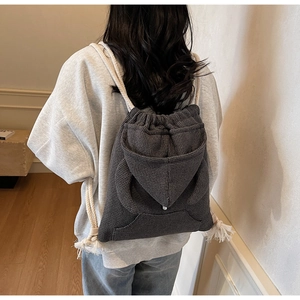 Detail of grey waffle textured drawstring backpack with cotton rope straps on model