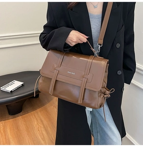 Detailed view of dark brown vintage faux leather messenger bag with wide strap