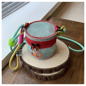 Close-up of vibrant mesh cylinder bag with colorful woven cords and neon zipper detail