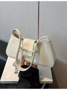 Chic cream white leather baguette bag with a bow accent and textured finish