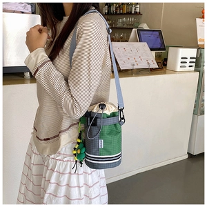 Detail of checkered cycling bottle bag with drawstring closure and sunflower charm