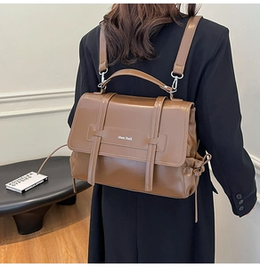 Detail view of the brown leather backpack with Moon SharK logo and flap closure