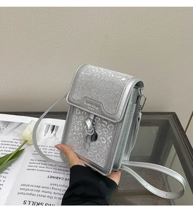 Detail of silver crossbody phone bag with leopard texture and metal fashion lettering