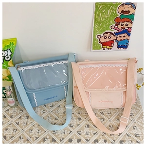 Close-up of canvas cross-body bags with clear PVC windows and white lace trim