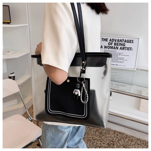 Détail d'un sac cabas transparent en PVC avec pochette noire et pendentif ours mignon