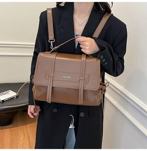Detail shot of the vintage brown leather shoulder bag with buckle straps and logo texture