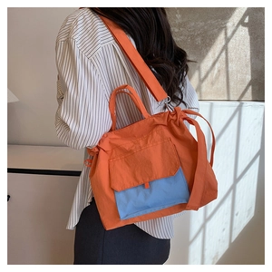 Vue détaillée du grand sac cabas en nylon avec panneaux contrastés orange et bleu clair