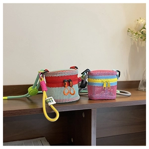 Detail view of colorful mesh cylinder mini bags with adjustable woven cords on a wooden shelf