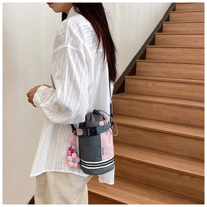 Detail of pink plaid bike bucket bag with drawstring closure and floral charm