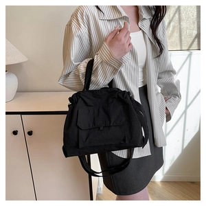 Détail d'un sac cabas en nylon noir avec poche avant à rabat pour un usage quotidien