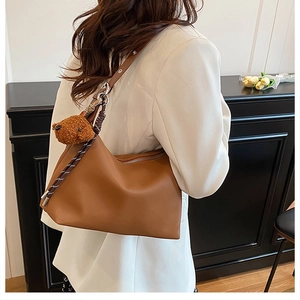 Sac hobo en cuir marron avec charm ours en peluche porté à l'épaule pour femme