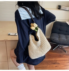 Detail of hand-woven cream cotton net tote bag with slim dark brown leather shoulder strap
