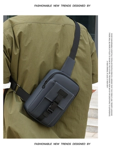 Detail view of a men's gray sport crossbody bag with adjustable strap and buckle on a model