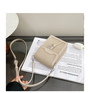 Detail of woven straw and smooth cream leather shoulder bag with adjustable strap