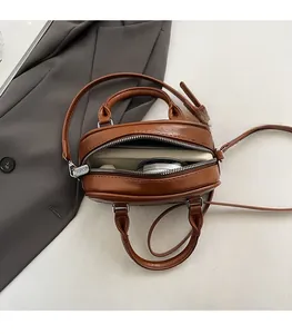Detailed interior of a vintage brown PU leather handbag with zipper closure and strap