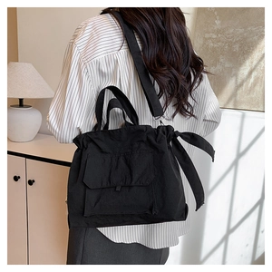 Détail du sac cabas en nylon noir avec fermeture à cordon et nœud en ruban élégant
