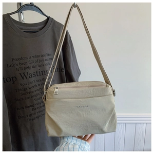 Close-up of beige waterproof nylon crossbody bag featuring DAIOU brand logo and zipper