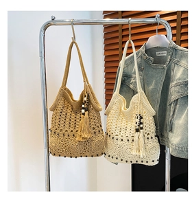 Detail of hand-woven crochet tote bags featuring geometric patterns and beaded tassels