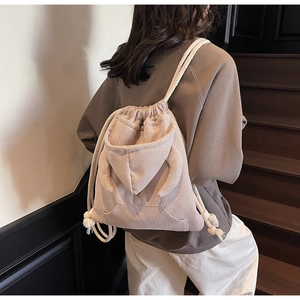 Detail view of beige checkered drawstring bucket bag with unique hoodie-inspired design