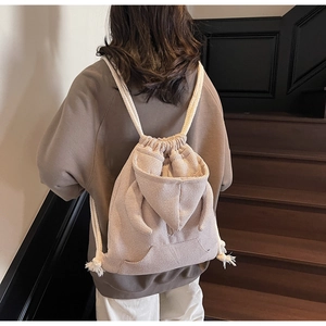 Detail of waffle-textured beige drawstring bucket bag with cute 3D long rabbit ears