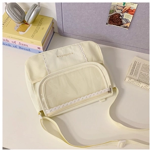Detail of off-white canvas messenger bag with mesh pockets, lace trim and star logo print