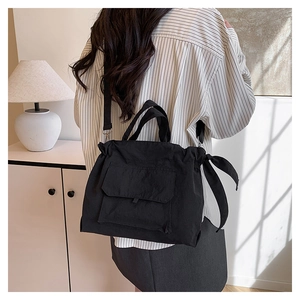 Détail du sac cabas en nylon noir avec bandoulière réglable et fermeture à cordon