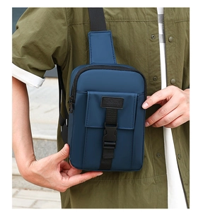 Detail showing durable navy nylon fabric and SPORT logo buckle on this athletic chest bag