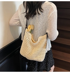 Detail of hand-woven crochet tote bag with mesh pattern and brown leather shoulder strap