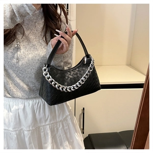 Detail of woven faux leather handbag with chunky silver chain and zip closure