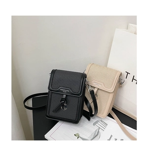 Detail view of mini square crossbody bags with woven texture and metal charms