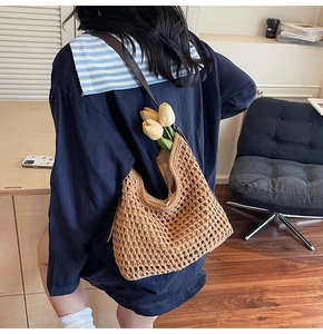 Detail of woven cotton shoulder bag featuring hollow mesh pattern and leather straps