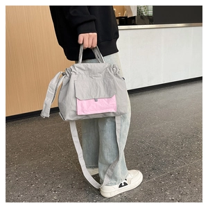 Détail du sac fourre-tout en nylon gris et rose avec cordon de serrage et poche avant