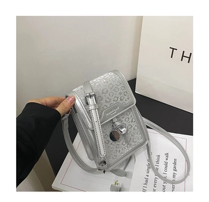 Close-up of silver glitter leopard print small square bag with metallic fashion logo