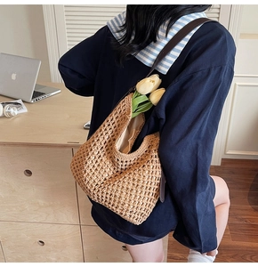 Close-up of hollow crochet cotton tote bag with brown leather strap and fabric lining