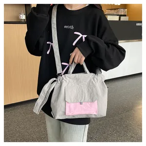 Détail du sac fourre-tout en nylon gris et rose avec texture plissée et bandoulière