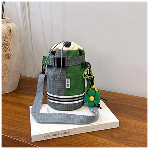 Close-up of checkered grey and green bike bottle bag with white logo and floral pendant