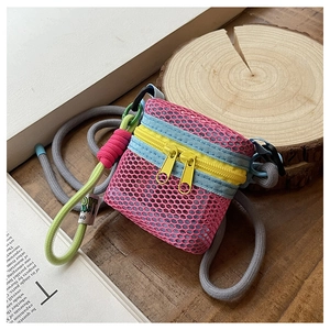 Detail of pink nylon mesh mini crossbody bag with yellow zippers and blue strap accents