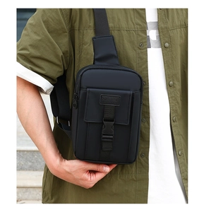 Detail of black sports crossbody bag with matte fabric and buckle closure on model