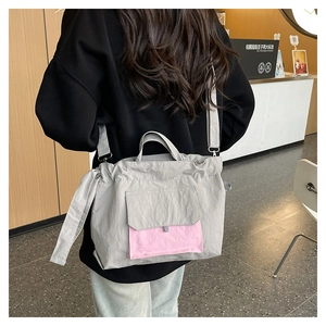 Détail du grand sac cabas en nylon gris avec poche rose contrastante style urbain
