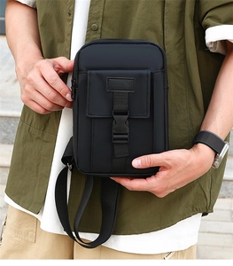 Detail of black waterproof nylon crossbody bag with buckle closure and adjustable strap