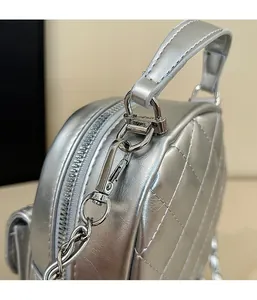 Close-up of detachable silver metal hooks and quilted leather texture on the backpack