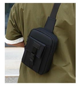 Close-up of black nylon chest bag with sport label and buckle closure worn by a model