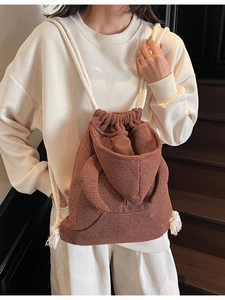Brown waffle texture bucket bag with drawstring and white rope straps on model