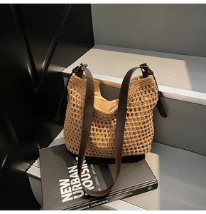 Detail of woven cotton shoulder bag featuring brown leather strap and mesh texture