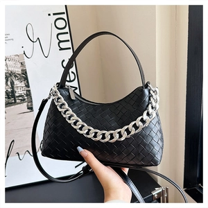 Detail of black woven leather hobo bag featuring chunky silver chain and handle
