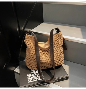 Detail of hand-woven cotton mesh tote bag with brown leather handles on urban book